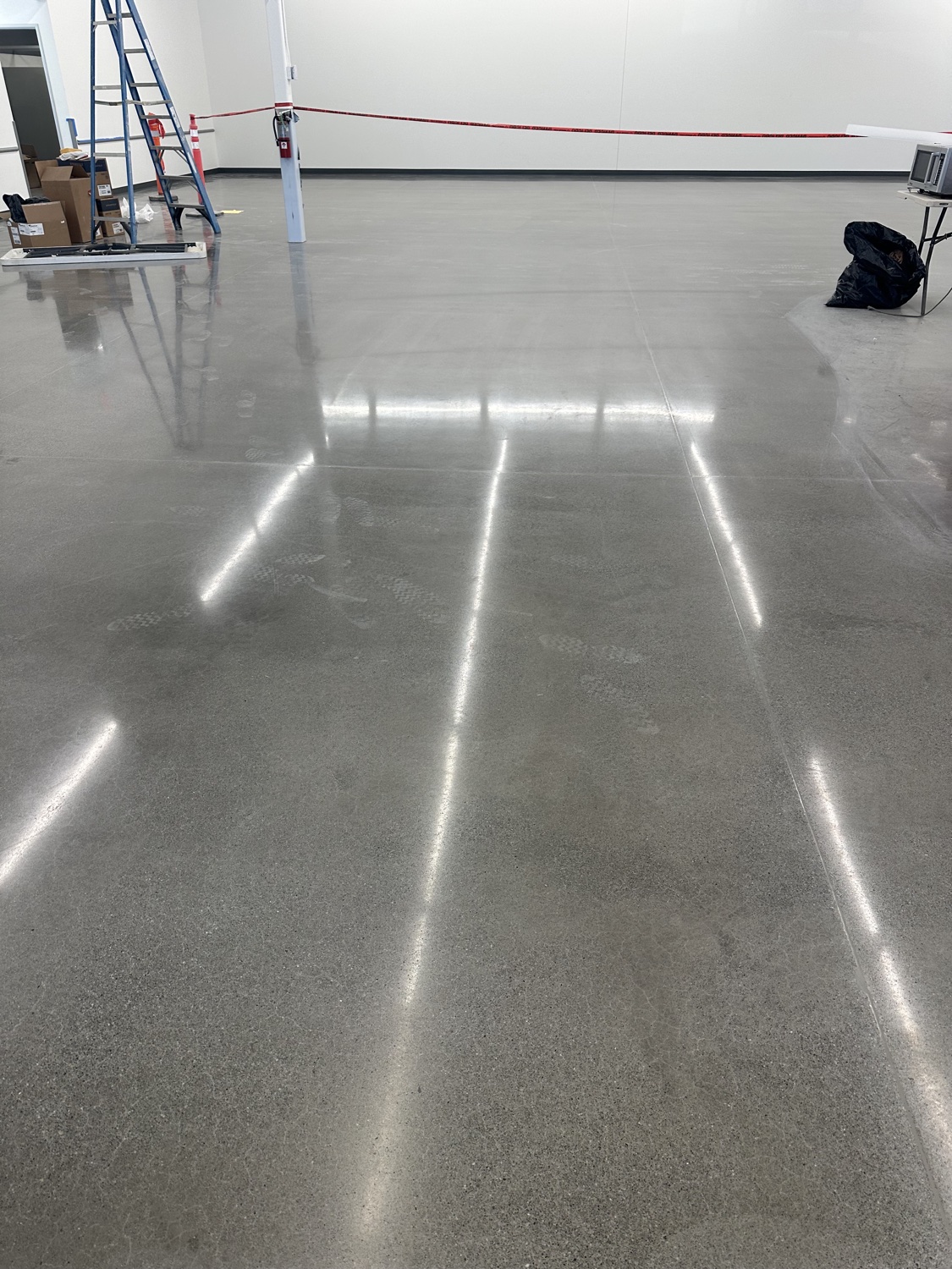 Close-up of the ground test patch edge against the stained exterior concrete