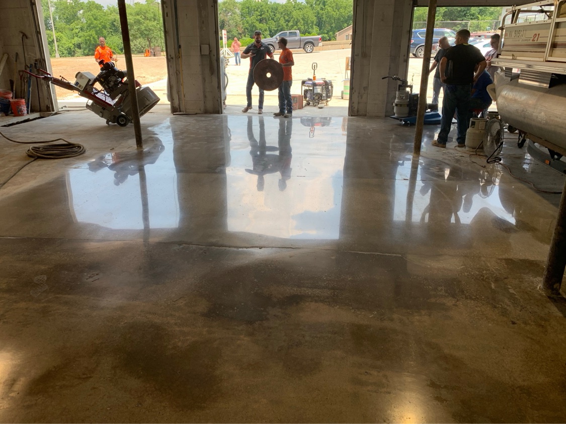 SHMAK crew gathered on a freshly polished concrete shop floor at handover
