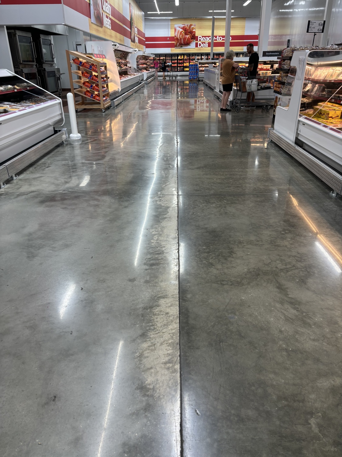 Polished concrete floor running along a grocery deli counter