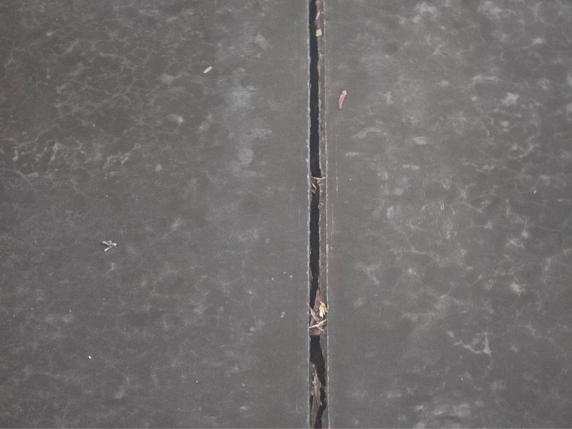 Close-up of a failed, open control joint with crumbling filler